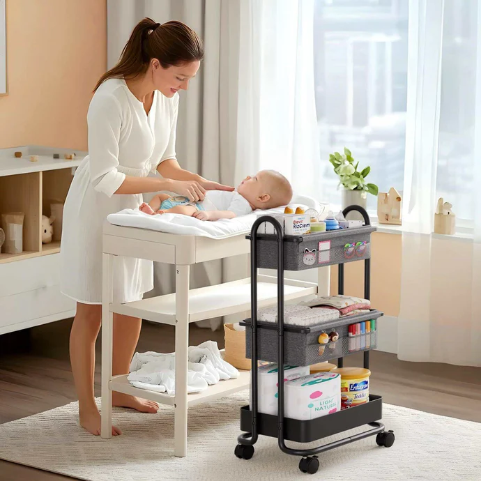 Woman changing a baby in a room with a trolley filled with supplies.shop_this_look_amDhCa