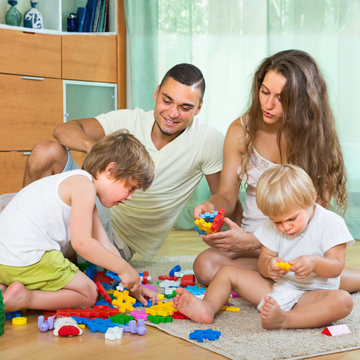 Toddler playing with educational toys while mother engages in early learning activities at home.